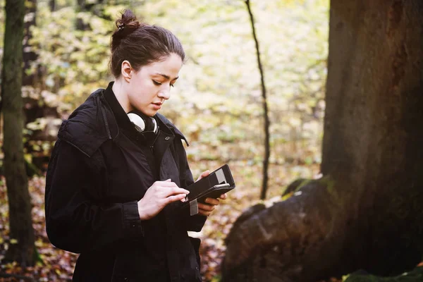 森の中の屋外で携帯電話を使う若い女性は — ストック写真