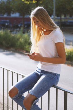 Sokakta akıllı telefon kullanan genç şehir kadını