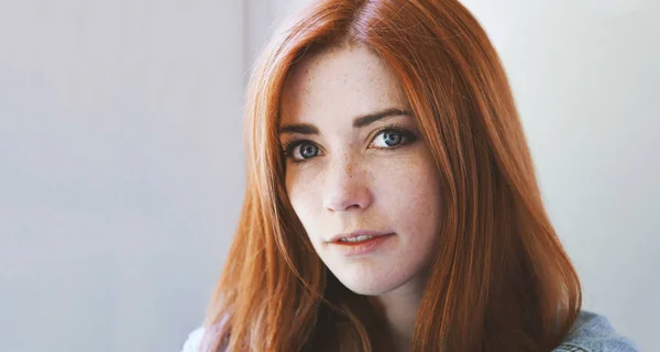 Retrato interior de mulher jovem com cabelo vermelho e sardas — Fotografia de Stock