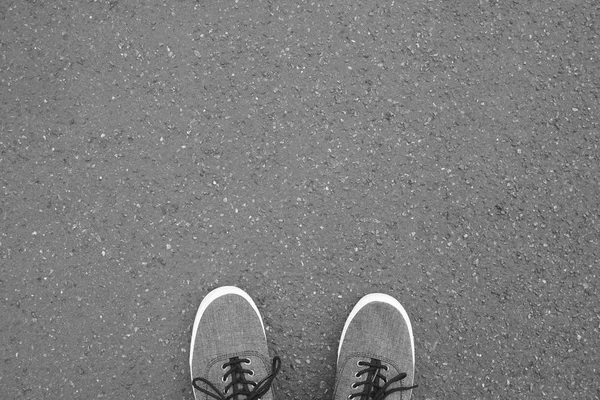 Pieds en toile chaussures debout sur la rue asphaltée — Photo
