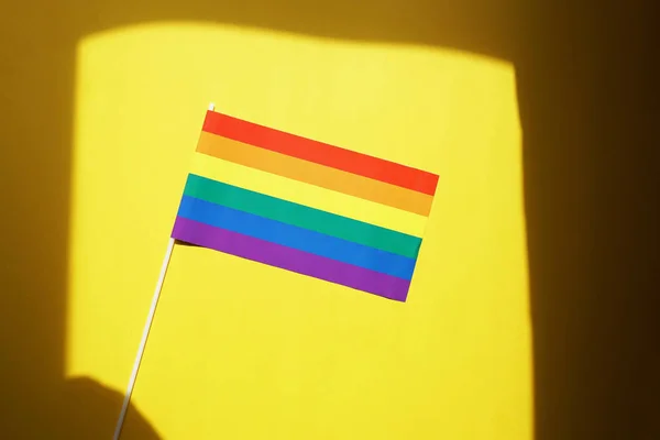 Tęcza flaga gej lub LGBT duma symbol przeciwko żółtym tle z ramki cienia Obrazek Stockowy