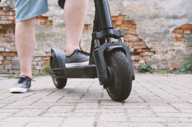 elektrikli tekme scooter veya e-scooter ile tanınmaz adam bacakları