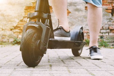 elektrikli tekme scooter veya e-scooter ile tanınmayan kişinin bacakları