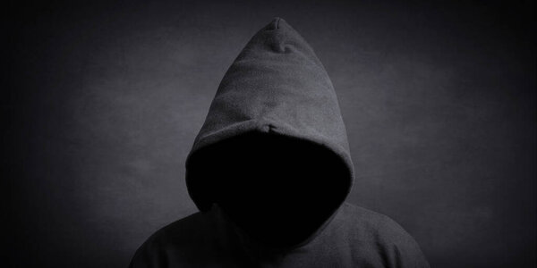 faceless person wearing black hoodie hiding face in shadow