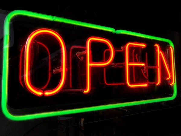 Otevřít v noci neonový nápis v okně obchodu — Stock fotografie