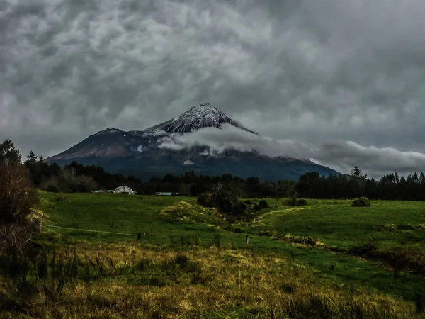 Taranaki veya Mount Egmont Vulcano bulutlu akşam kar ile.