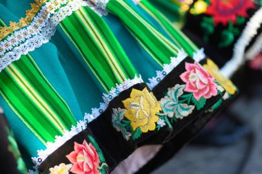 Bölgesel, işlemeli folklor kostümleri, çizgileri ve sembolleri renkli el yapımı etek. Corpus Christi geçit töreni sırasında. 