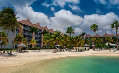 Oranjestad, Aruba - Ekim 12,2007: gölgesinde istirahat turist palmiye ağaçları Beach otel tatil turkuaz denizin kenarında şezlong üzerinde. 