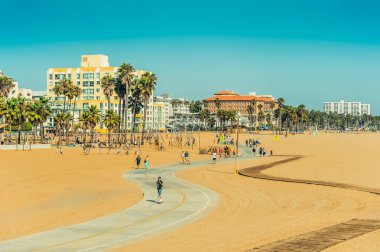 Los Angeles/California/ABD - 07.22.2013: kum arasında iz insanlar bisiklet üzerinde paten kurulu ve bisiklet sürme. Kidd'ın mavi gökyüzü güneşli gün parkta oynarken. 