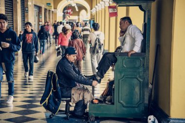 Lima / Peru - 07.18.2017: Bootblack ayakkabı parlatma sokakta çalışan adam.