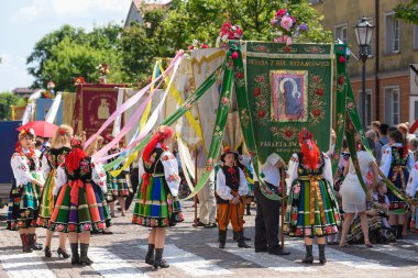 Lowicz / Polonya - 31.2018 olabilir: Corpus Christi kilise tatil alayı. Halk, renkli çizgili bölgesel kostümler giymiş kadınların folklor sembolleri, beyaz gömlek işlemeli. Güneşli gün. 
