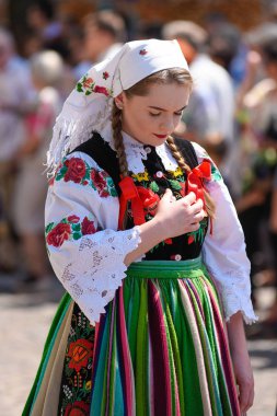Lowicz / Polonya - 31.2018 olabilir: Corpus Christi kilise tatil alayı. Halk, renkli çizgili bölgesel kostümler giymiş kadınların folklor sembolleri, beyaz gömlek işlemeli. Güneşli gün. 