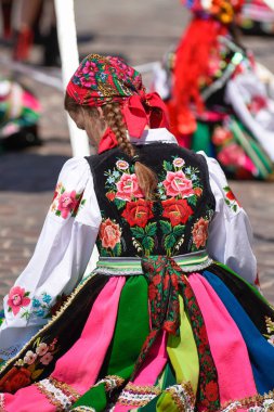 Lowicz / Polonya - 31.2018 olabilir: Corpus Christi kilise tatil alayı. Halk, renkli çizgili bölgesel kostümler giymiş kadınların folklor sembolleri, beyaz gömlek işlemeli. Güneşli gün. 