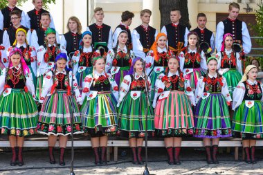 Lowicz / Polonya - 31.2018 olabilir: yerel, bölgesel koro genç kadın ve erkek folklor kostümleri giymiş. Renkli etek ve pantolon, beyaz gömlek, canlı baş fuları, siyah yelek. 