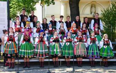 Lowicz / Polonya - 31.2018 olabilir: yerel, bölgesel koro genç kadın ve erkek folklor kostümleri giymiş. Renkli etek ve pantolon, beyaz gömlek, canlı baş fuları, siyah yelek. 