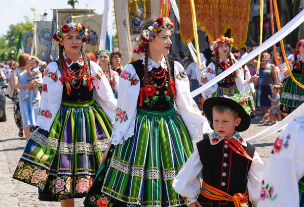 Lowicz / Polonya - 31.2018 olabilir: Corpus Christi kilise tatil alayı. Halk, renkli çizgili bölgesel kostümler giymiş kadınların folklor sembolleri, beyaz gömlek işlemeli. Güneşli gün. 