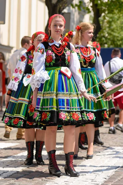 Lowicz / Polonya - 31.2018 olabilir: Corpus Christi kilise tatil alayı. Halk, renkli çizgili bölgesel kostümler giymiş kadınların folklor sembolleri, beyaz gömlek işlemeli. Güneşli gün. 