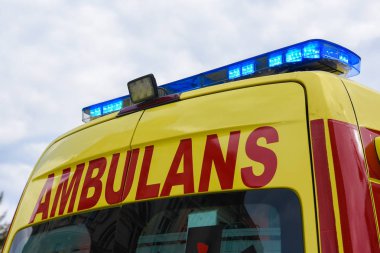 Sarı ambulans araba mavi neon uyarı ışıkları ile.