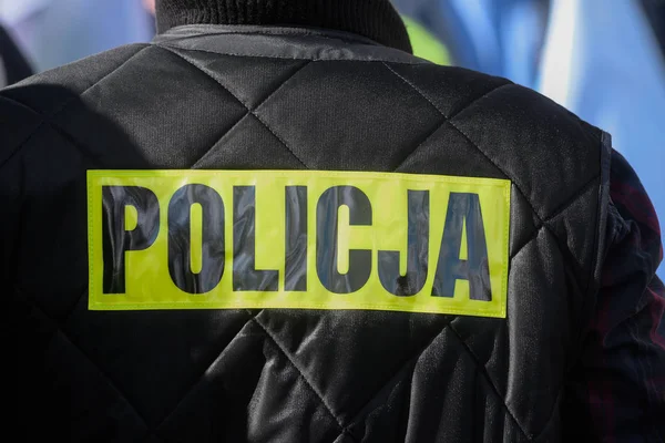 Police sign/logo on the back of the police uniform.