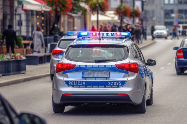 Kırmızı ve mavi neon uyarı ışıkları yanıp sönen ile devriye polis arabası.