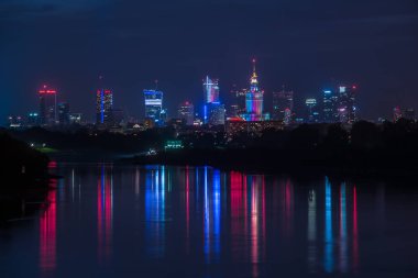 Varşova şehir binaları ışık yansıması nehre ile gece görünümü.