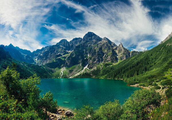 View on the turquoise color lake between high and rocky mountains. Beautiful alpine landscape. 