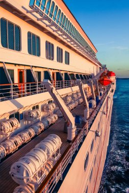 Cruise gemi güverte üzerinde görünümü, deniz yolculuğu sırasında gün batımında filika ve konuklar kabin. 