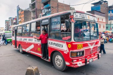 Lima / Peru Haziran 13.2008: Çok popüler şehir ulaşım otobüsü kapıda duran ve Gamarra ilçesinde sokakta yüksek sesle otobüs durakları çağıran kişi ile. Gündüz. 