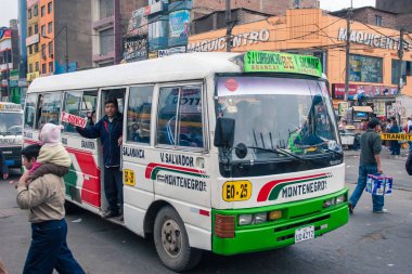 Lima / Peru Haziran 13.2008: Çok popüler şehir ulaşım otobüsü kapıda duran ve Gamarra ilçesinde sokakta yüksek sesle otobüs durakları çağıran kişi ile. Gündüz. 