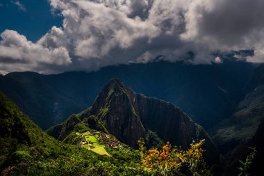 Gün batımı nda İnka kutsal şehir kalıntıları ile Machu Picchu / Huayna Picchu dağ görkemli hava görünümü. Ön planda güzel yeşillik. 