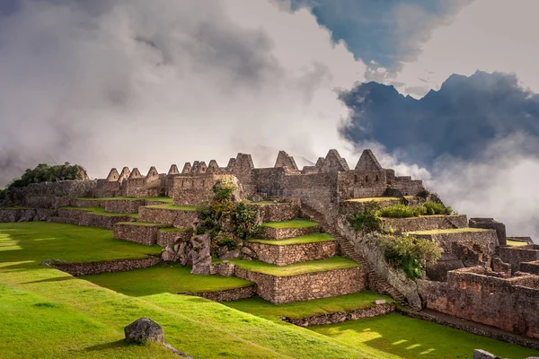 Machu Picchu şehir kalıntıları üzerinde mistik görünümü bulutların yalak geçen güneş ışınları ile sis ile kaplı. Gün doğumu sırasında İnka Kutsal şehir. 