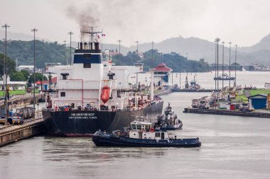 Panama Kanalı / Panama - 18.Mayıs 2007: Panama Kanalı'ndan geçen büyük geminin manzarası. Bir sürü makine, bu mühendislik operasyonunda arabaları nalları katıyor. Bulutlu bir gün. 