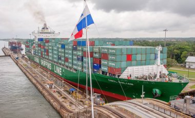 Panama Kanalı / Panama - 18.Mayıs 2007: Panama Kanalı'ndan geçen büyük konteyner gemisinin tam dolu yelkenine bak. Gemi yavaş yavaş çekme arabaları bağlı kilitleri arasında hareket ediyor. Bulutlu bir gün.