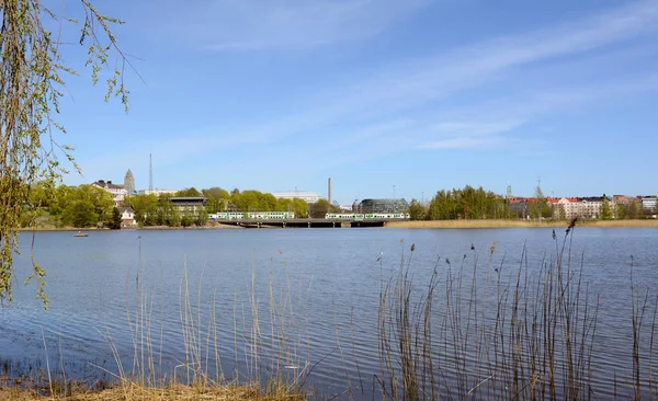 VR Pendolino trains cross a bridge on the far side of Toolo bay in Helsinki City Park