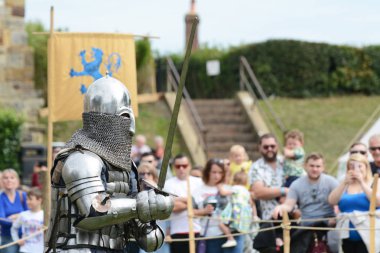 Tonbridge, İngiltere - 9 Eylül 2018: Tam savaş regalia CHAINMAIL siperliği ile Ortaçağ şövalye kılıcı Tonbridge bir şatoda bir kalabalığın önünde savaş canlandırma, brandishes