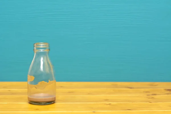 Ένα Τρίτο Γυάλινο Μπουκάλι Γάλα Κατακάθια Από Μιλκσέικ Σοκολάτας Ξύλινο — Φωτογραφία Αρχείου