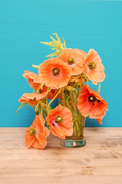 Vase of pale pink poppies on a wooden table — Stock Photo, Image