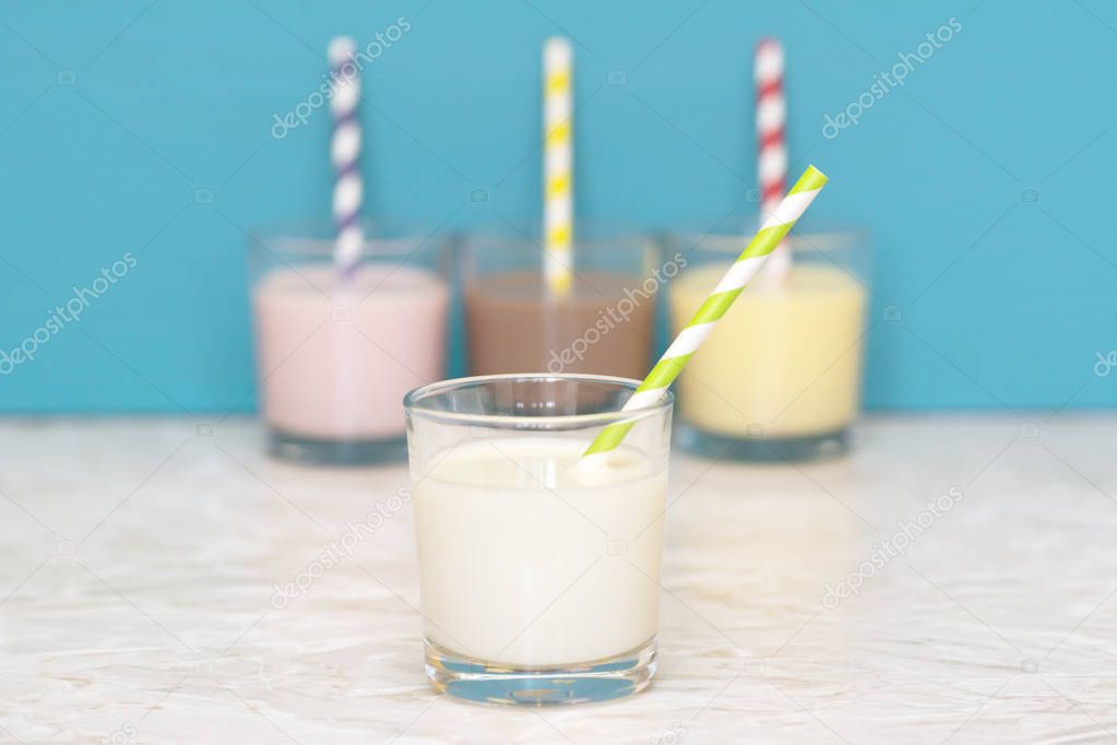 Fresh milk in front of a row of flavoured milkshakes