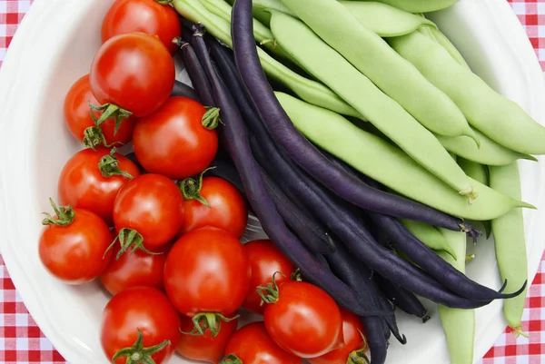 Cherry tomatoes with purple French beans and green Calypso beans — Stock Photo, Image