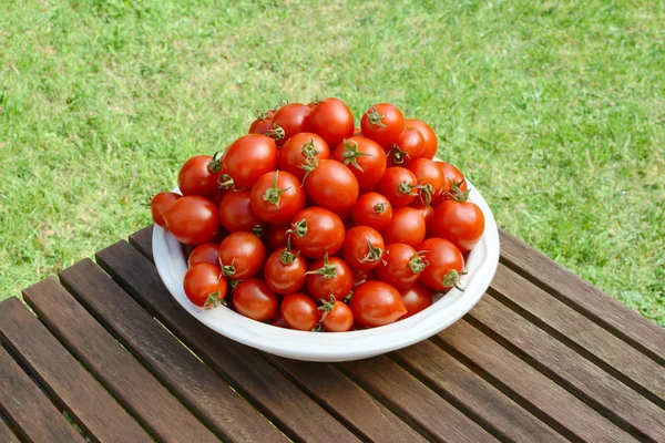 Montón de jugosos tomates cherry frescos en un plato blanco — Foto de Stock