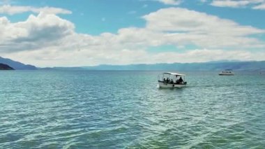 Makedonya, Ohri - Jun, 2017 yaklaşık: ağır çekim turist teknenin yolcuları Ohri Gölü en iyi ile geleneksel turu taking ufukta görüntülemek eski şehir mimarisi