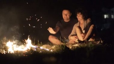 Romantik Çift nightime, kamp ateşi etrafında oturan