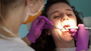 Diş hekimi profesyonel diş diş ofisinde Bayan genç hasta temizlik yapma