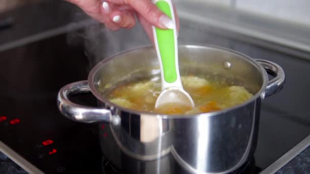 lassú mozgás, női kéz tészta leves zöldség forrásban lévő pot ellenőrzése