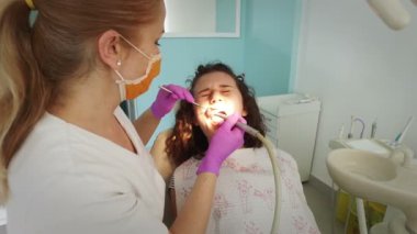 Diş hekimi profesyonel diş diş ofisinde Bayan genç hasta temizlik yapma