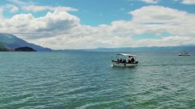 Makedonya, Ohri - Jun, 2017 yaklaşık: zaman atlamalı yourist teknenin yolcuları Ohri Gölü en iyi ile geleneksel turu taking ufukta görüntülemek eski şehir mimarisi