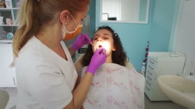 Diş hekimi profesyonel diş diş ofisinde Bayan genç hasta temizlik yapma