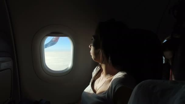 Mujer Joven Mirando Por Ventana Avión Mientras Sol Brilla Cara — Vídeos de Stock