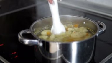 Kadın el sebze kaynar ile tencerede erişte çorbası kontrol yakın çekim