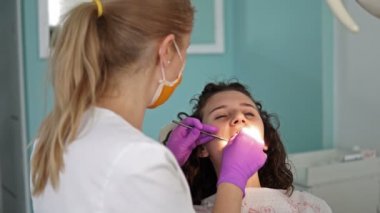 Diş hekimi profesyonel diş diş ofisinde Bayan genç hasta temizlik yapma